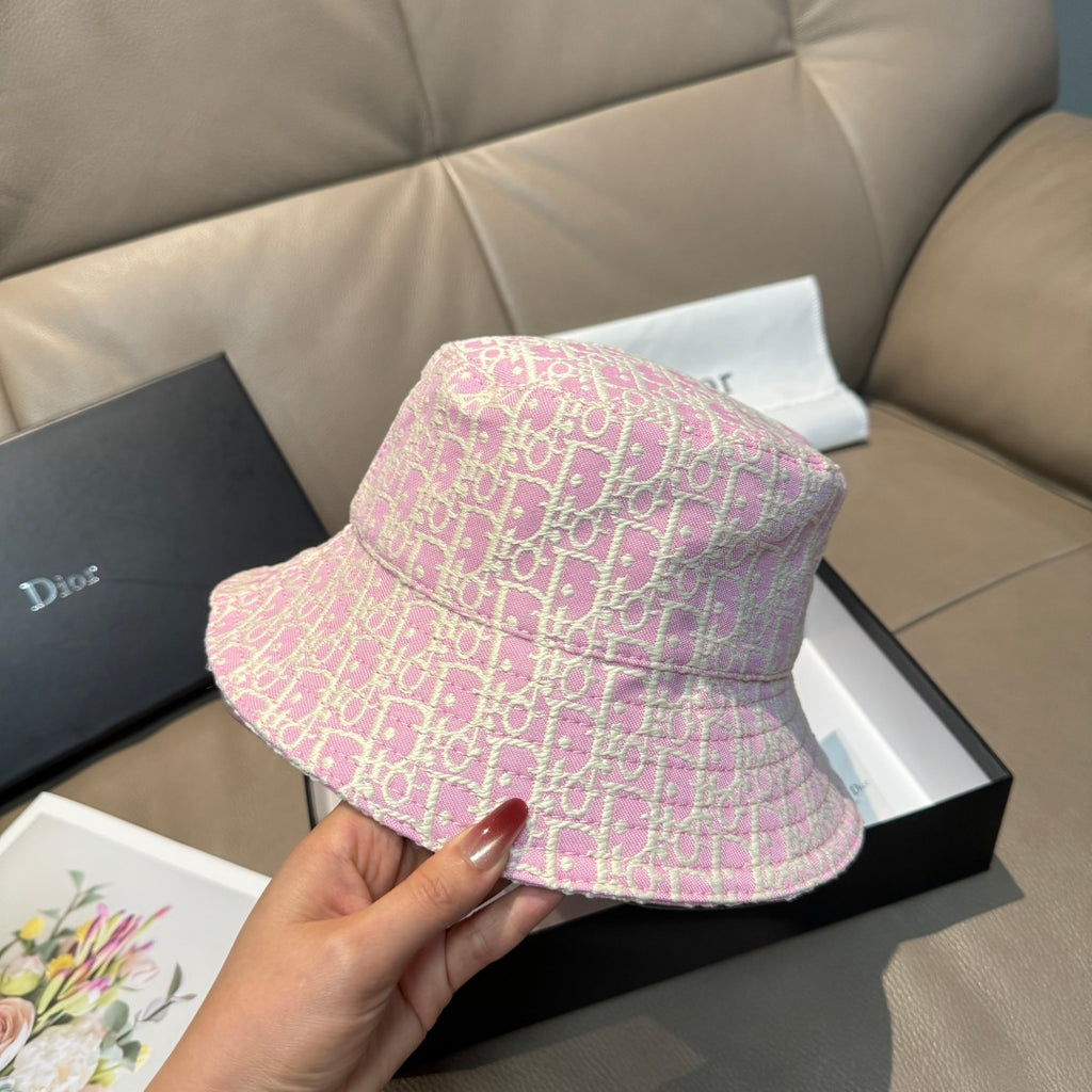 Dior pink monogram bucket hat with wide brim, held by hand
