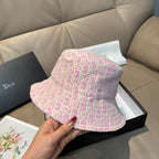 Dior pink monogram bucket hat with wide brim, held by hand
