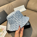 Dior monogram bucket cap in light blue with white pattern, held by hand