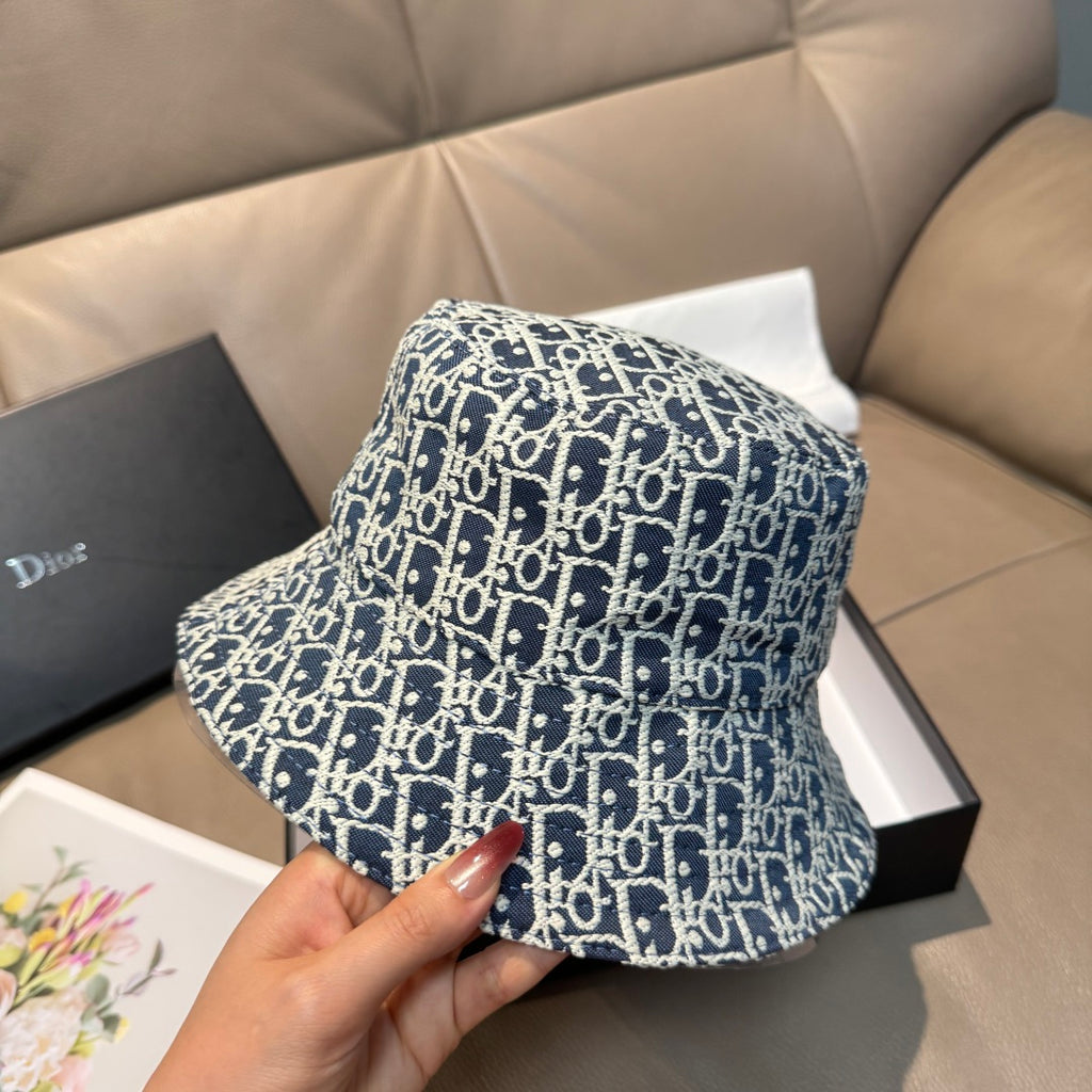 Monogram bucket cap in navy with white pattern, front/side view held by hand