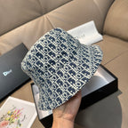 Monogram bucket cap in navy with white pattern, angled view on gift box