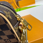 Louis Vuitton monogram bag corner with gold hardware and zipper pull, dark navy and beige.