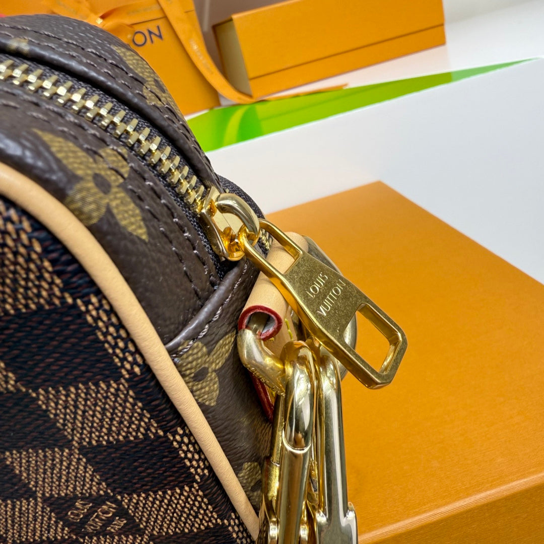 Louis Vuitton monogram bag corner with gold hardware and zipper pull, dark navy and beige.
