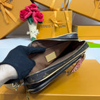 Louis Vuitton crossbody bag open with brown lining and label, viewed from above, monogram.