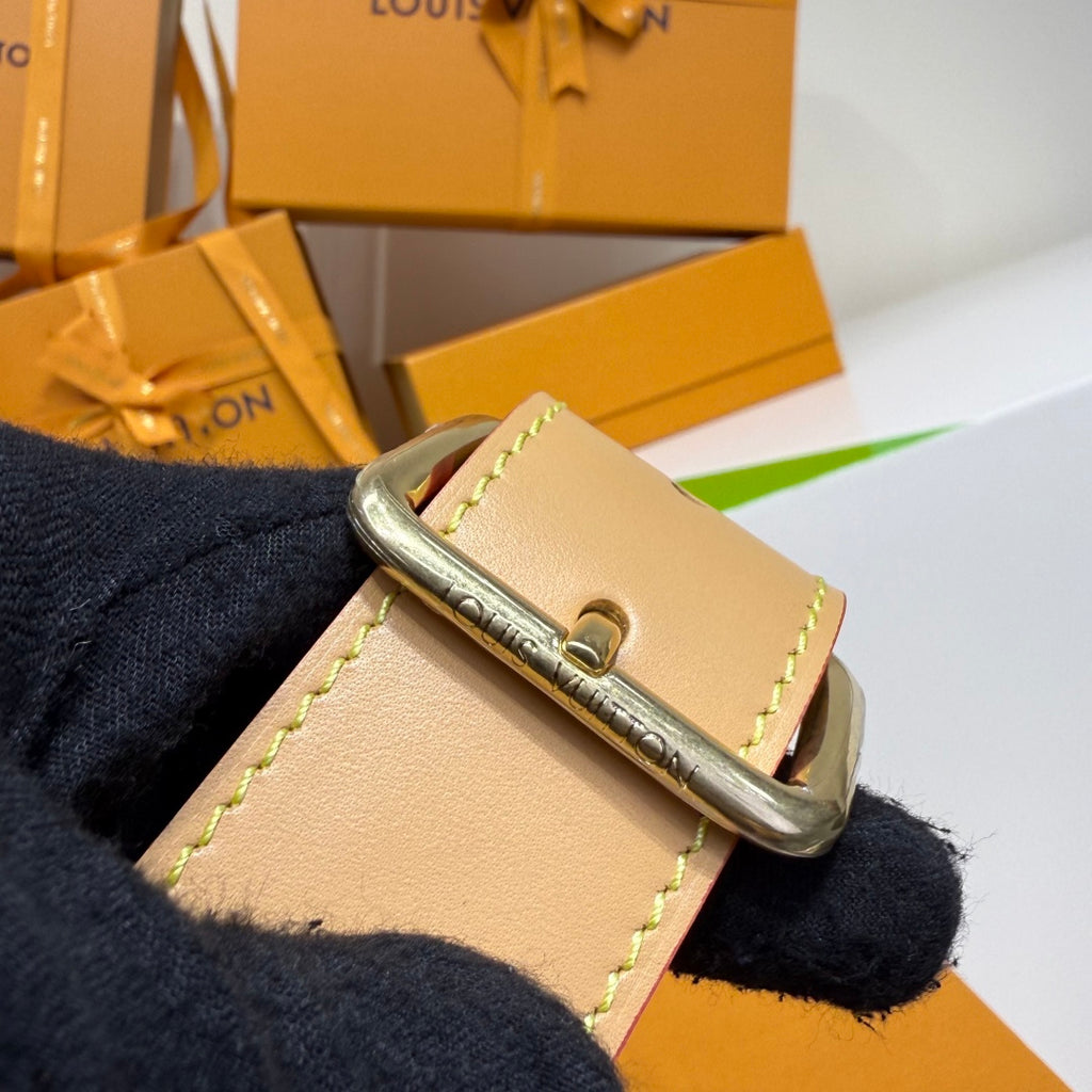 Louis Vuitton belt bag strap attachment ring with pale leather tab and gold hardware, dark blue.