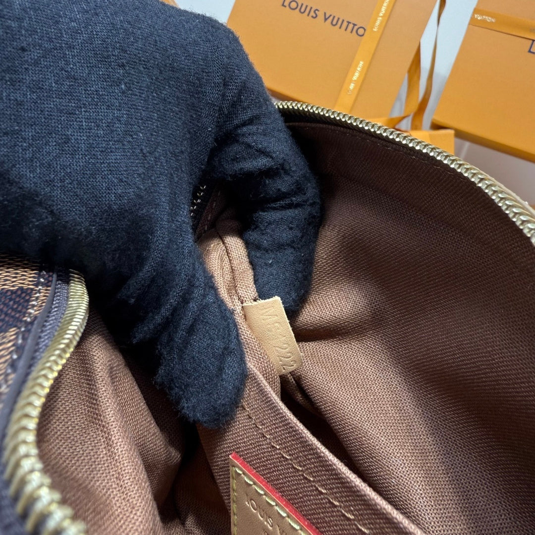 Louis Vuitton crossbody bag interior close-up with brown lining and stitched pocket edge