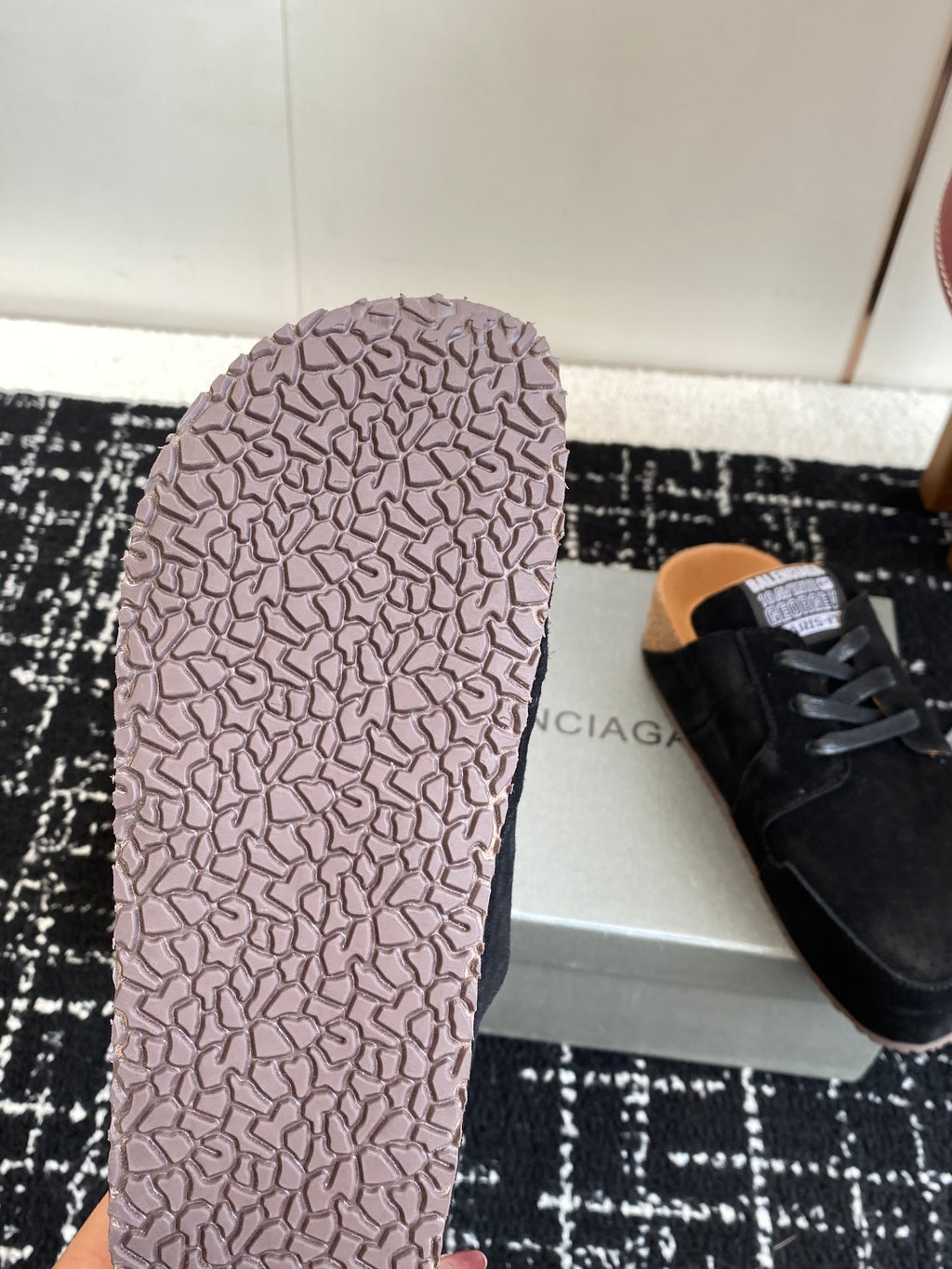 Light pink rubber outsole with tread pattern, underside of black sneaker