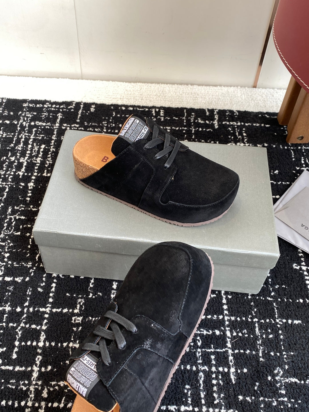 Black suede lace-up sneakers with tan lining, one sole facing up