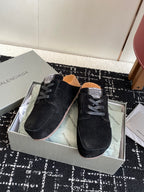 Balenciaga dark suede lace-up shoes with gray laces, angled on display box