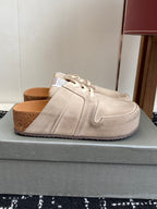 Single light tan lace-up sneaker on a box, side profile