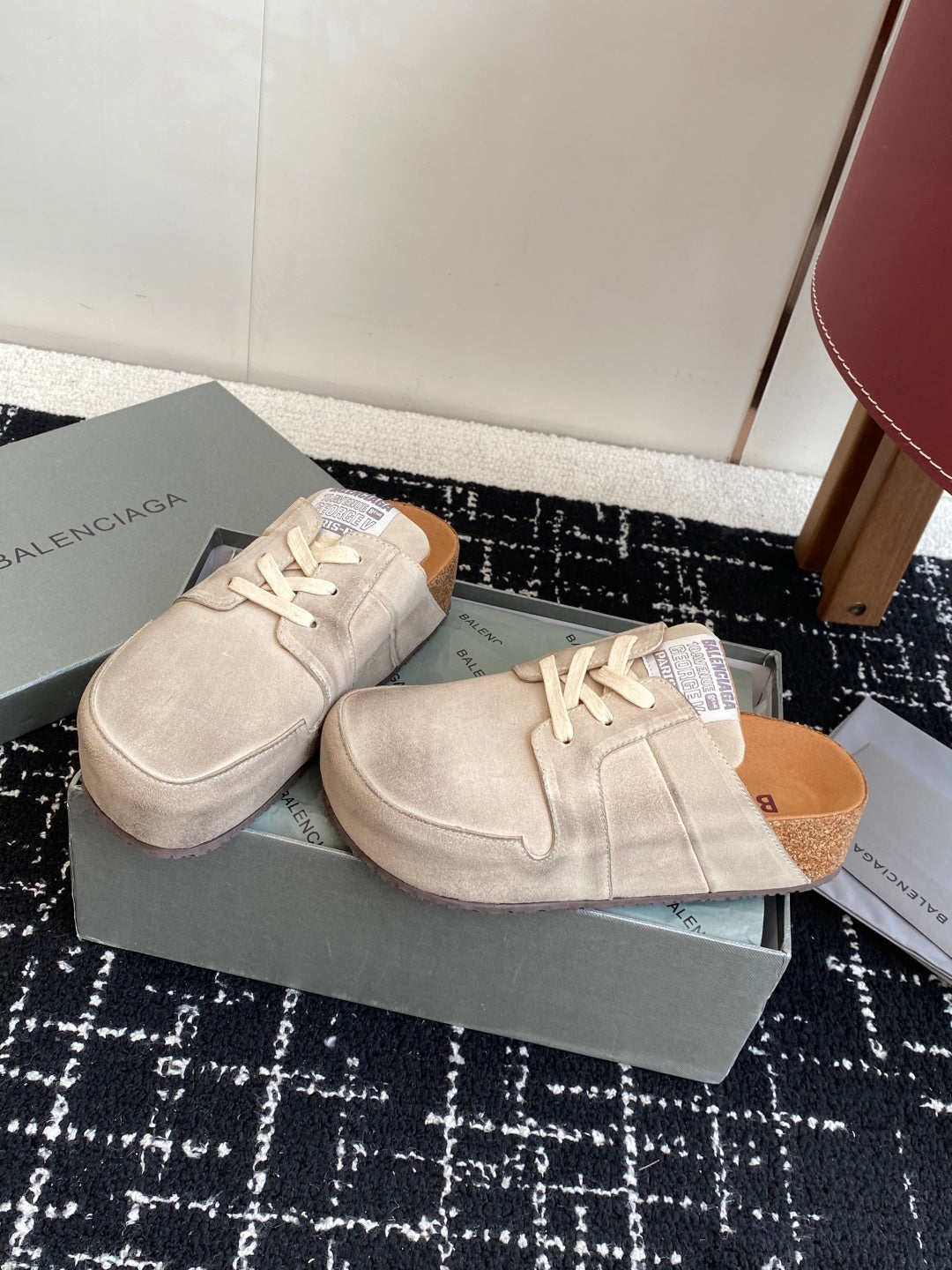 Two light tan lace-up sneakers on a box, top views