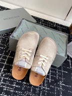 Light tan lace-up sneakers in a shoebox with tan insoles visible