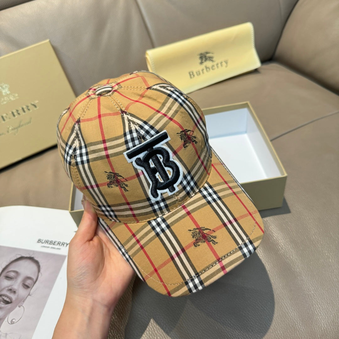 Plaid baseball cap on hand with embroidered monogram logo; tan, red, black, and white pattern