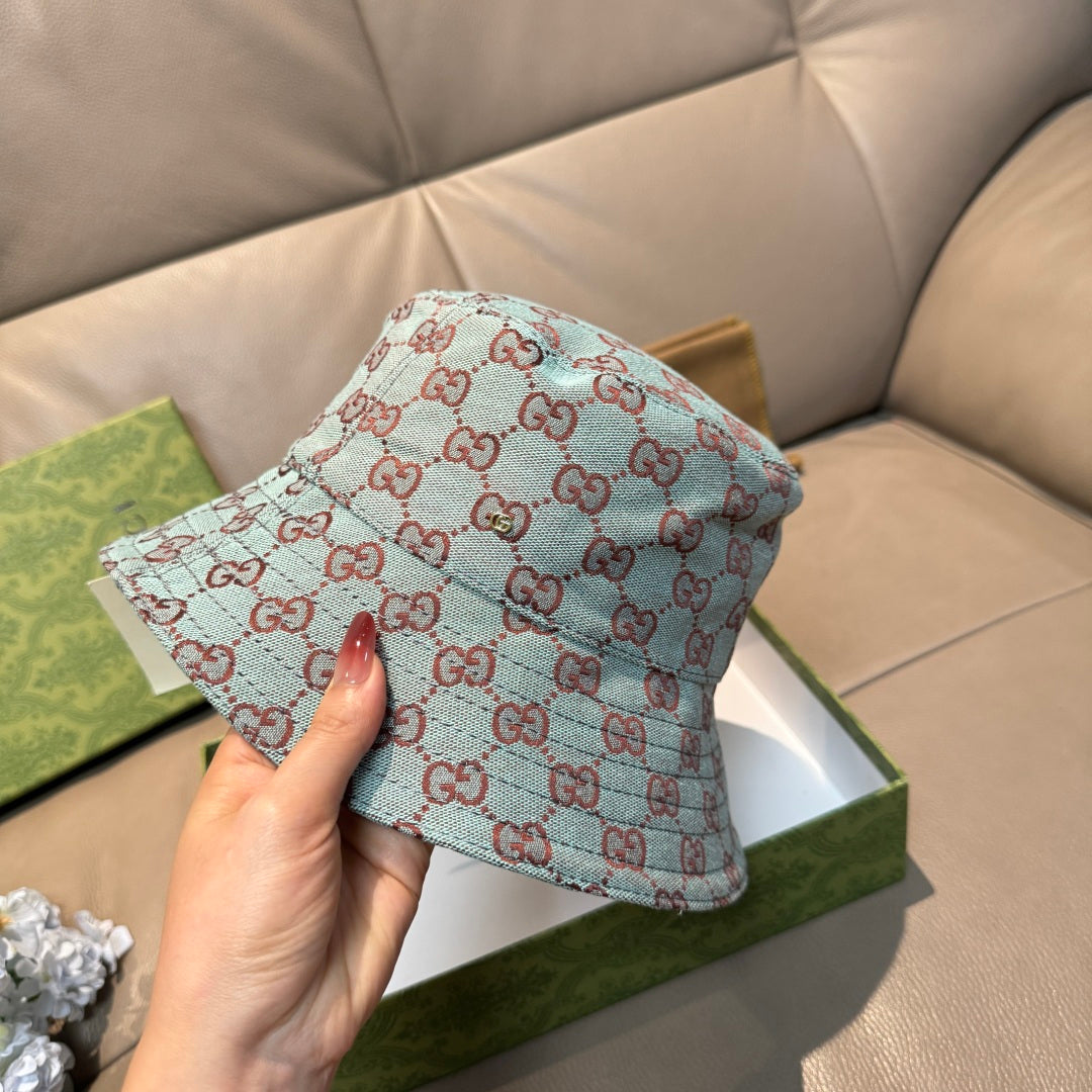 Gucci bucket hat in light blue with red GG monogram pattern, hand holding