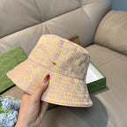 Gucci bucket hat front view, light pink with neon green GG logo print