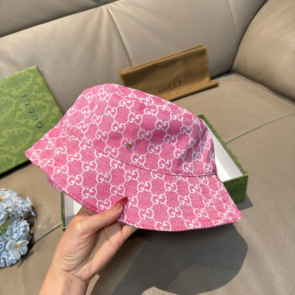 Pink bucket hat with white GG monogram pattern, held from underside view
