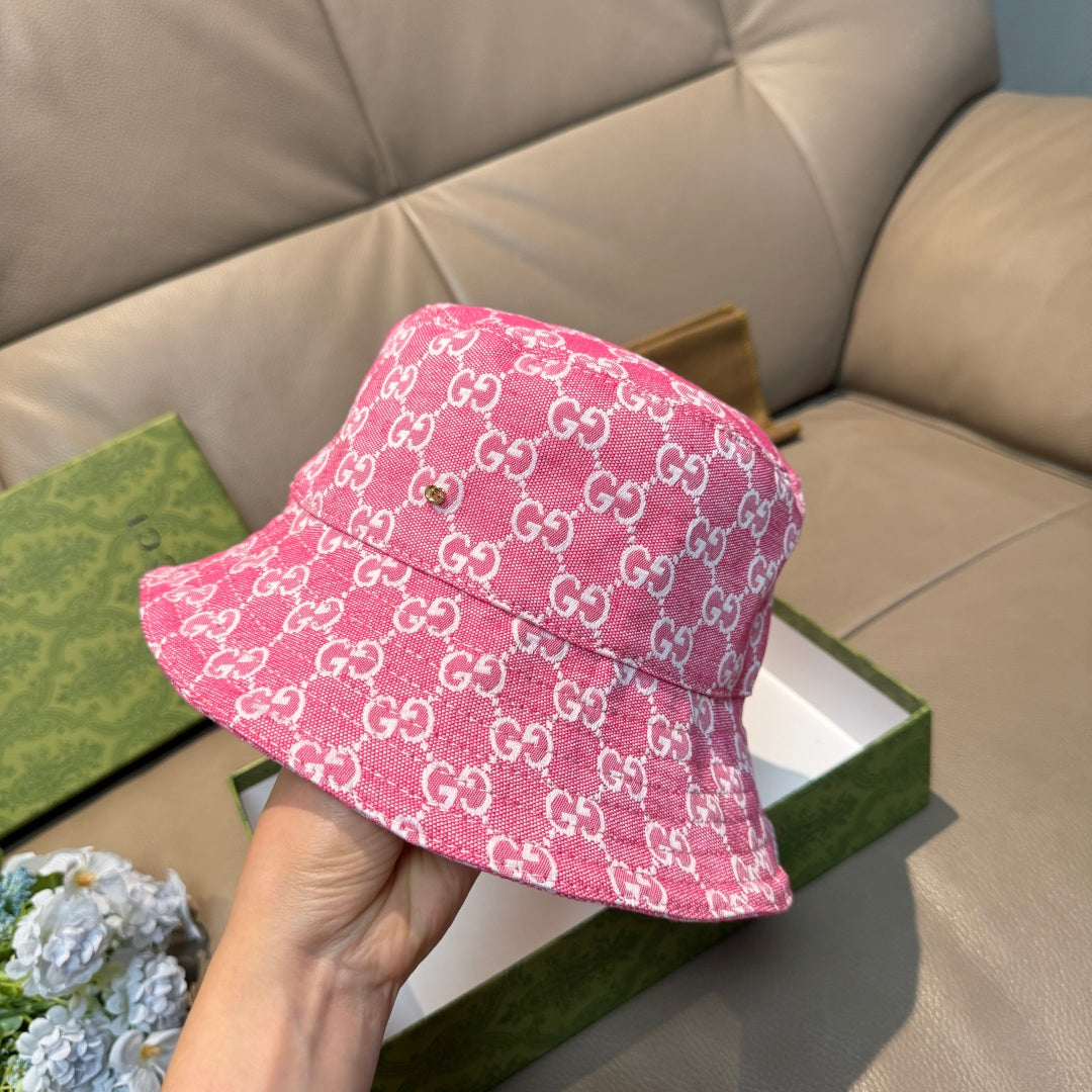Pink bucket hat with white GG monogram pattern, held up in front view