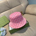 Pink bucket cap with white GG monogram pattern and curved brim