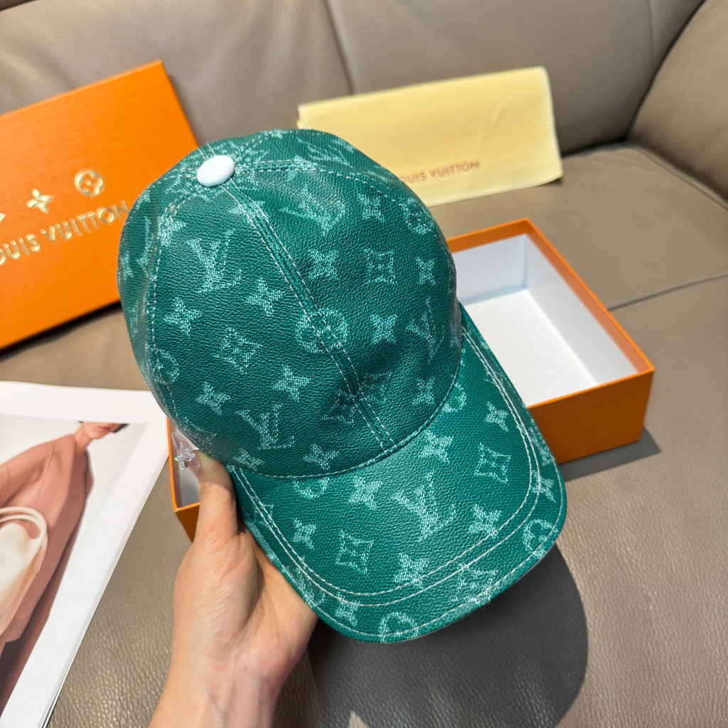 Louis Vuitton green monogram cap held in hand, angled view