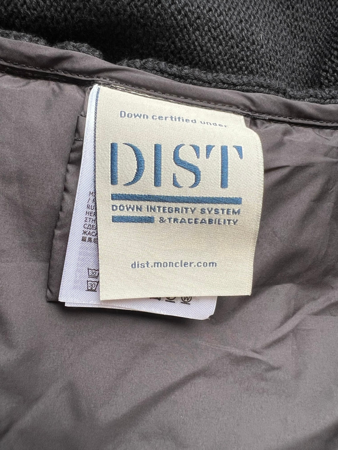Down-certified fabric label reading DIST on Moncler puffer jacket lining