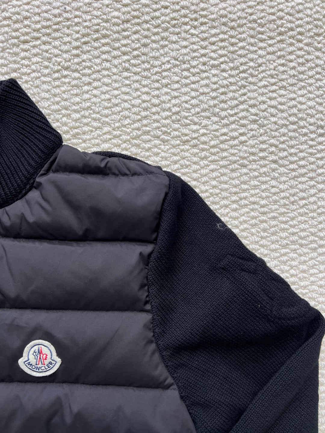 Moncler long puffer jacket side view with sleeve knit cuff and small logo patch