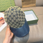 Gucci GG monogram baseball cap with dark blue leather brim, angled view