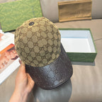 Gucci cap closeup: beige GG crown with dark leather-look brim, snap button
