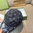 Black GG monogram cap with curved brim; front shows white floral graphic