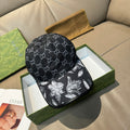 Black GG-print cap with curved brim and monochrome floral graphic panel on front