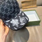 Close-up of black brim cap with GG monogram top and white floral graphic