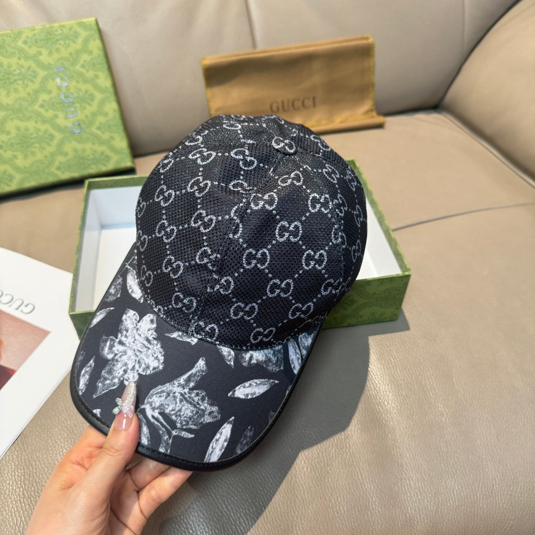 Black GG monogram cap viewed from side, with curved brim and white floral panel