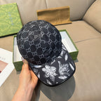 Black monogram baseball cap with curved brim and white floral graphic on front