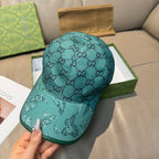 Gucci teal monogram baseball cap, front view with eagle motif on brim