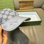Gucci baseball cap side view, gray GG monogram crown and curved brim.