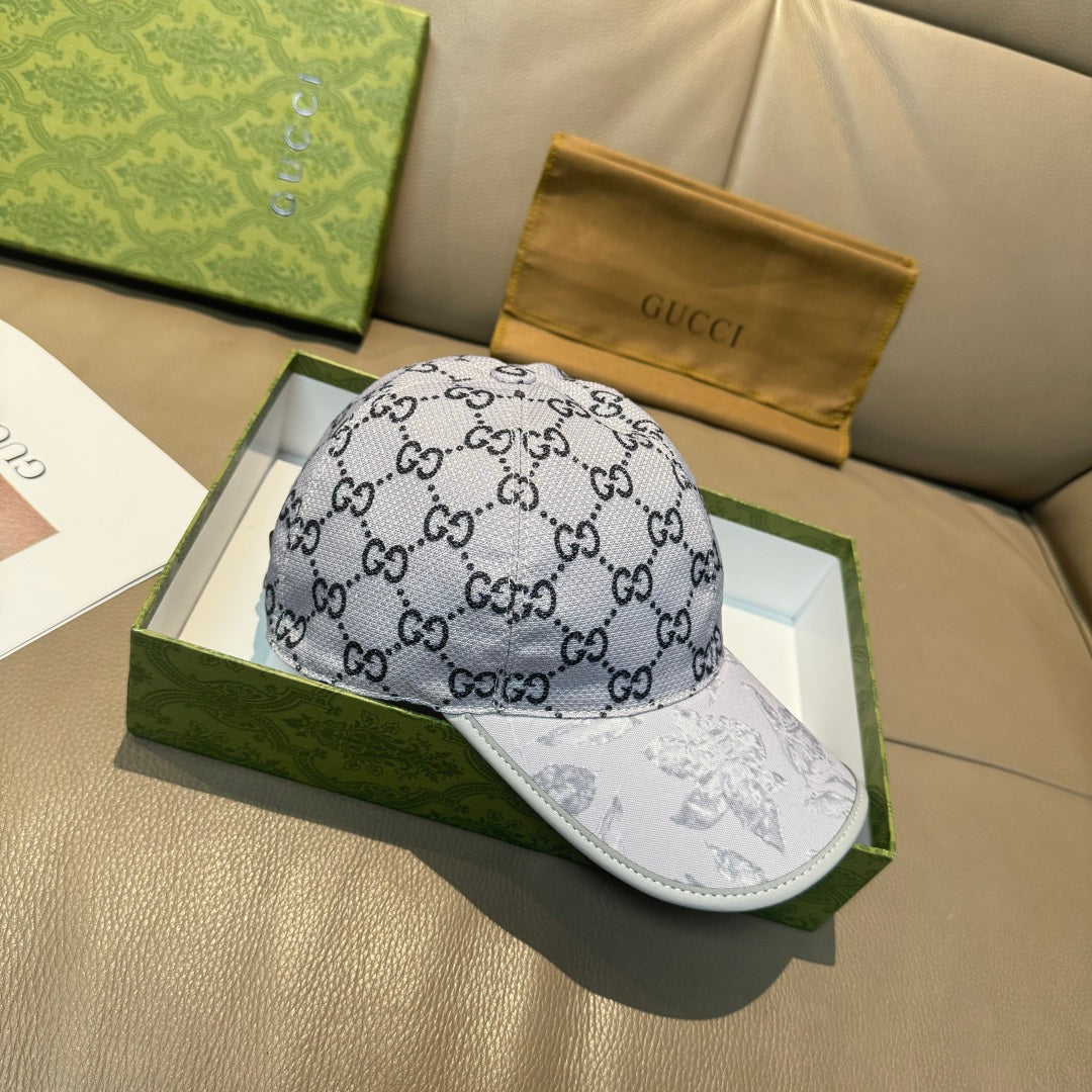 Gucci baseball cap with gray GG monogram pattern and white bill with artwork.