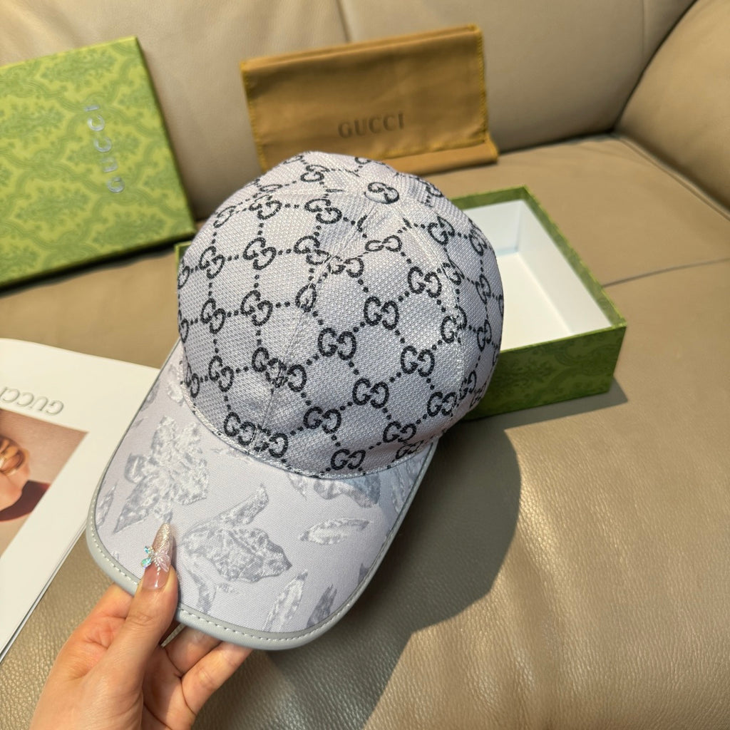Gucci baseball cap with gray GG monogram on crown and white illustrated brim.