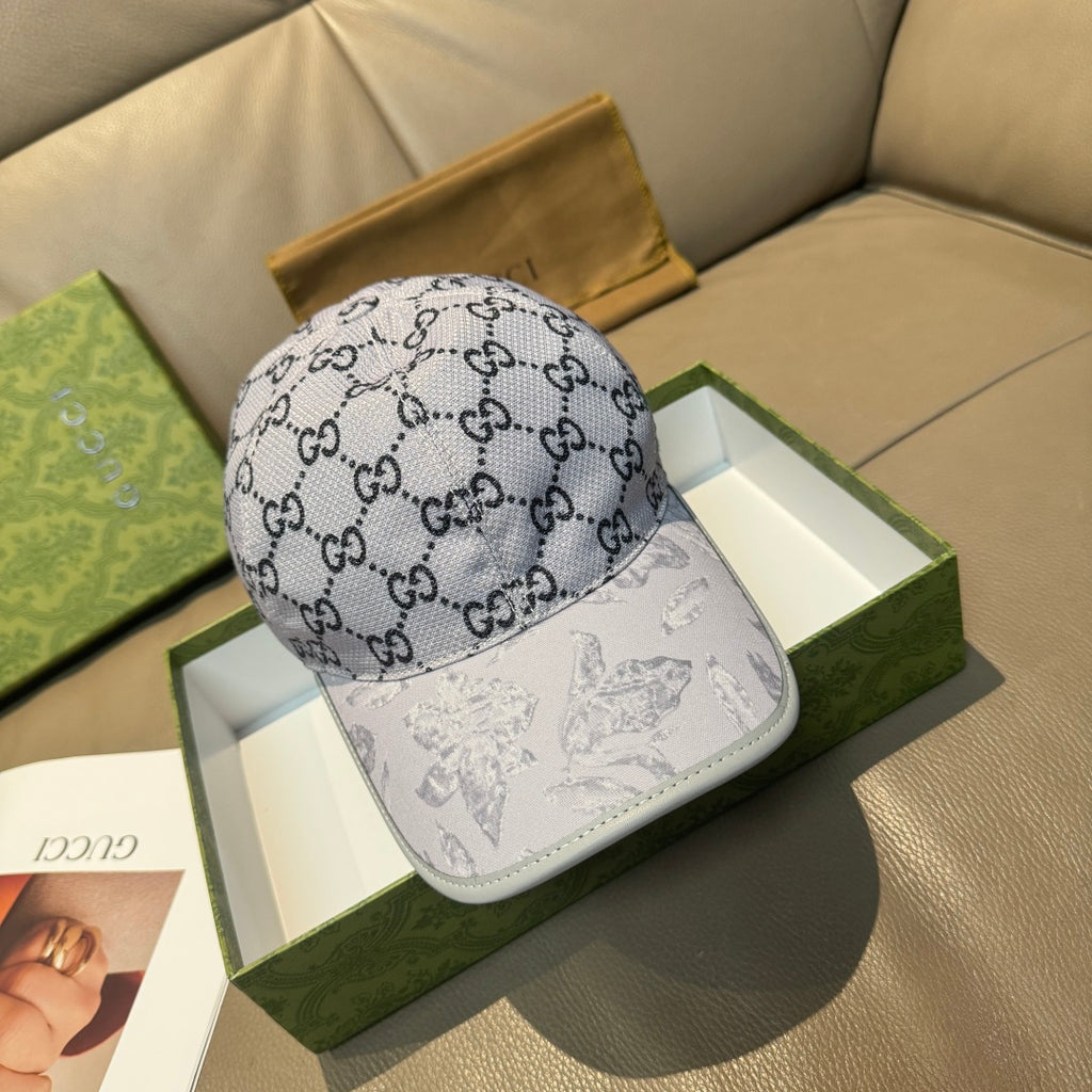 Gucci baseball cap with gray GG monogram print and white front panel.