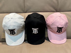 Three caps: white, black, and pink with TB logos and curved brims