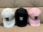 Three baseball caps: white, black, and pink, each with a TB logo on the front