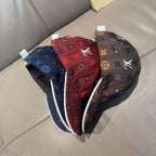 Two Louis Vuitton monogram baseball caps: dark brown and red/blue, curved brims