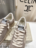 Golden Goose gray low-top sneakers close-up of white laces and tongue label