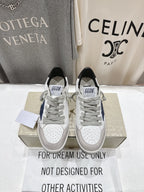 White luxury sneakers with gray laces, perforated toe, and GGD B label on tongue