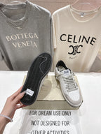 White luxury sneakers with gray laces and perforated toe; tread sole shown