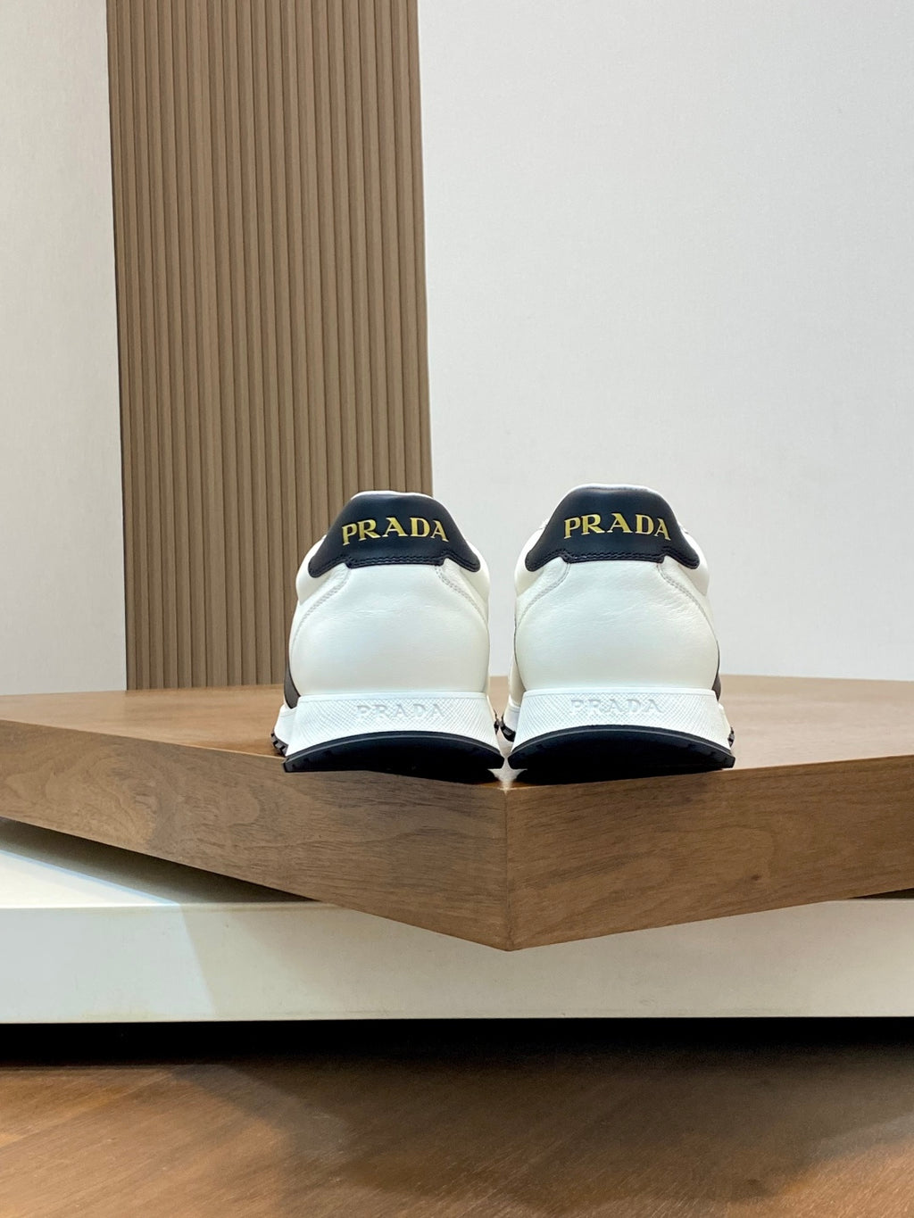 Back view of white Prada sneakers with black heel tabs and branding