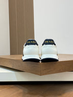Back view of white Prada sneakers with black heel tabs and branding