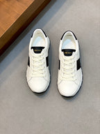 White low-top sneakers with black side stripe and lace-up front, Prada logo detail