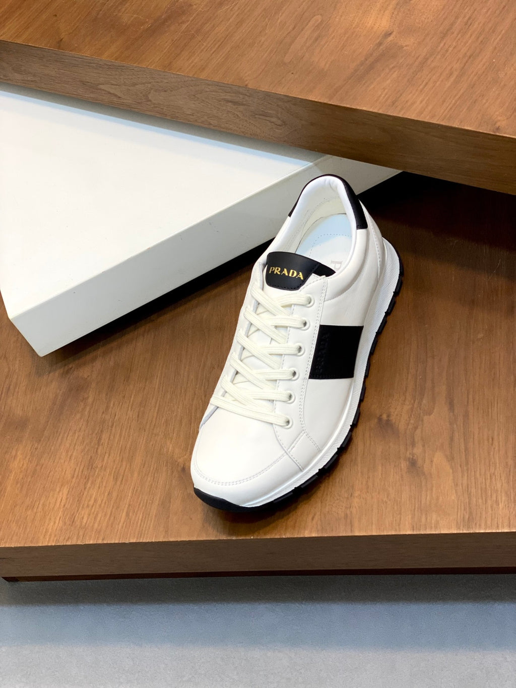 White lace-up sneakers with black side stripe and padded collar