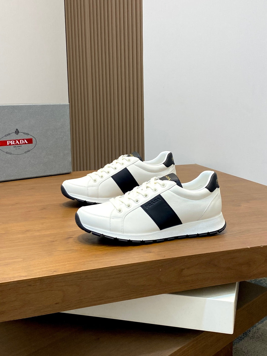 Pair of white low-top sneakers with black side stripe and lace-up design