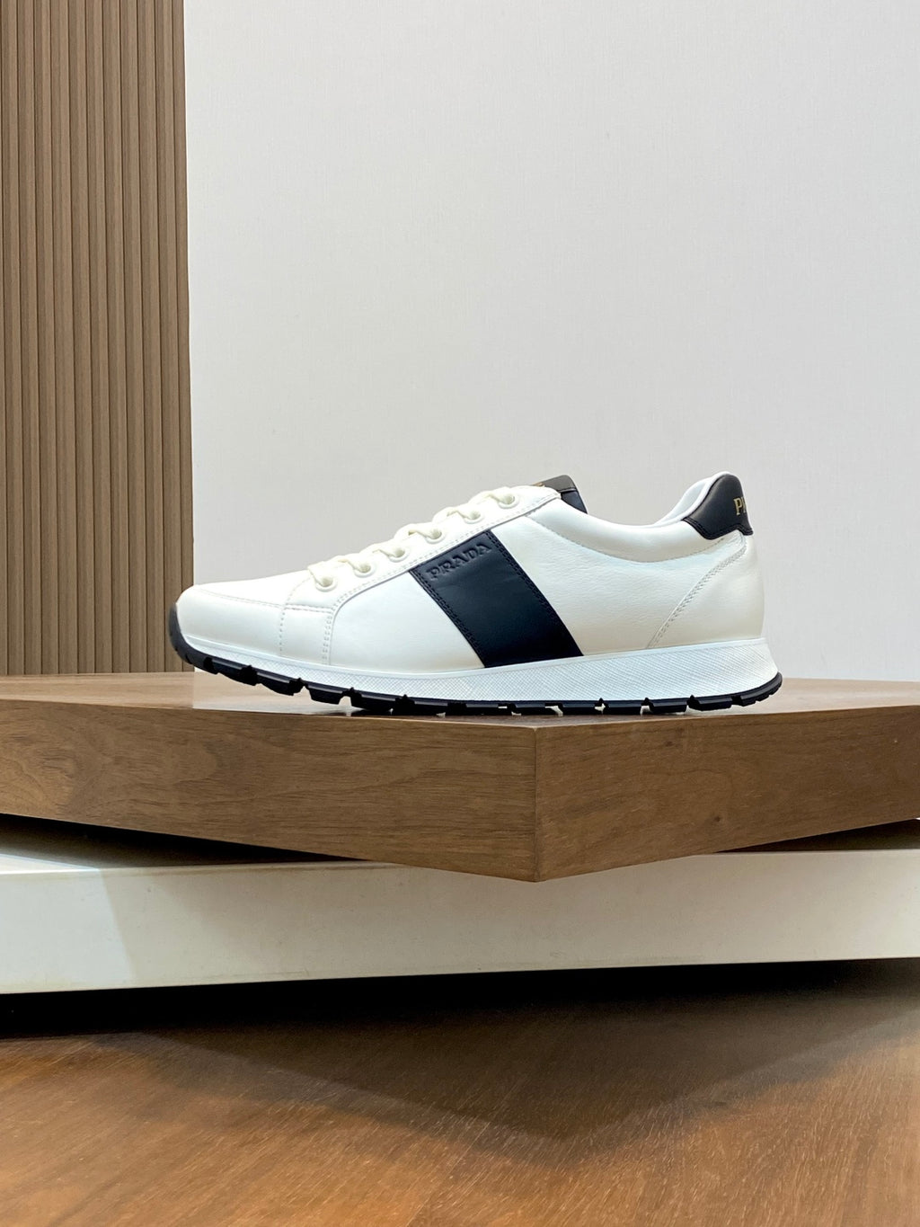 White low-top sneakers with black side band and textured rubber sole