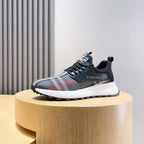 Dark lace-up sneaker with BURBERRY check stripe and white midsole on pedestal